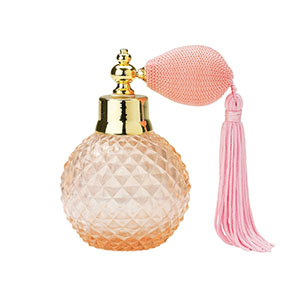 A pink perfume bottle with a tassel on top.