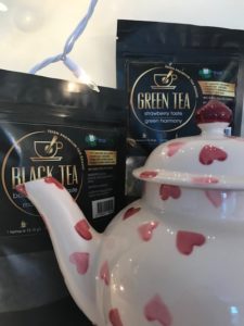 A teapot and some bags of tea on the table