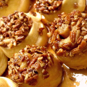 A close up of some baked donuts with nuts