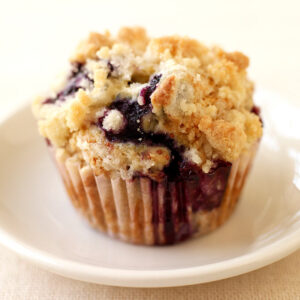 A muffin sitting on top of a white plate.