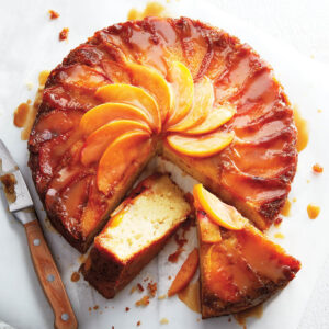 A cake with orange slices and caramel on top.