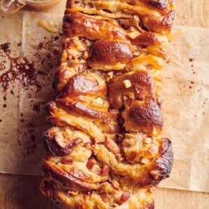 A loaf of bread with cheese and sausage on it.