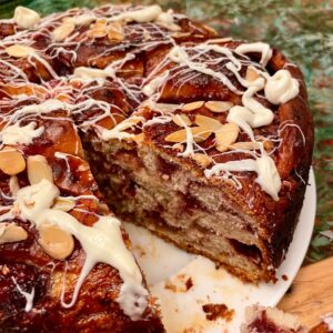 A cake with white frosting and almonds on top.